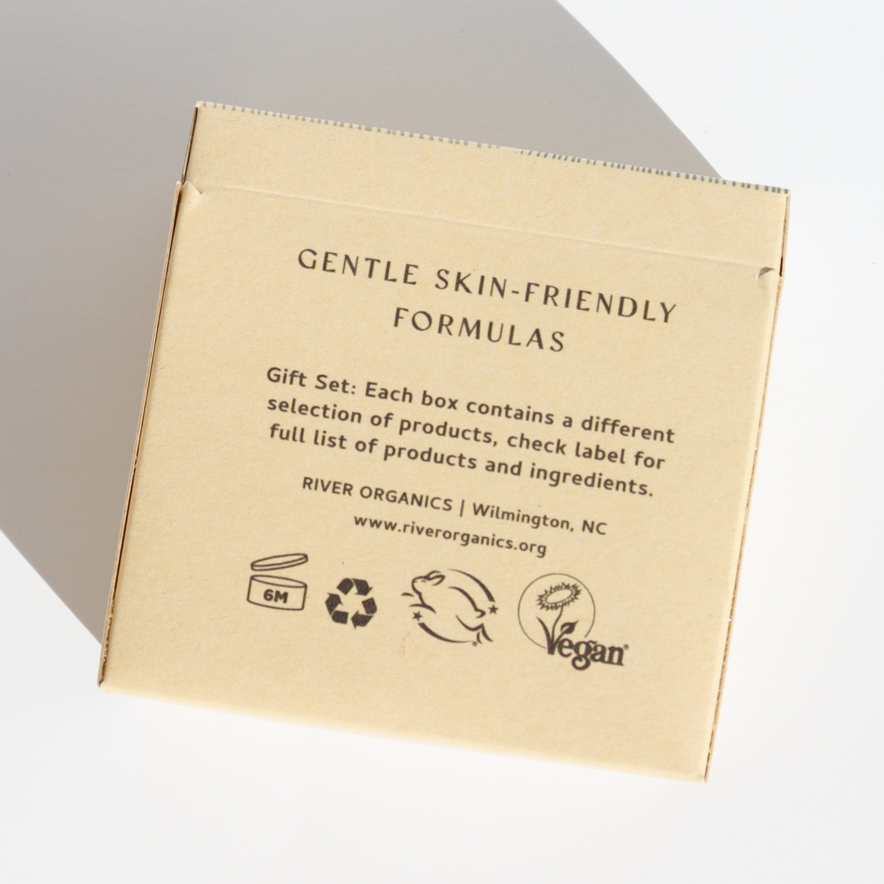 Brown paper box with text and logos on a light gray background