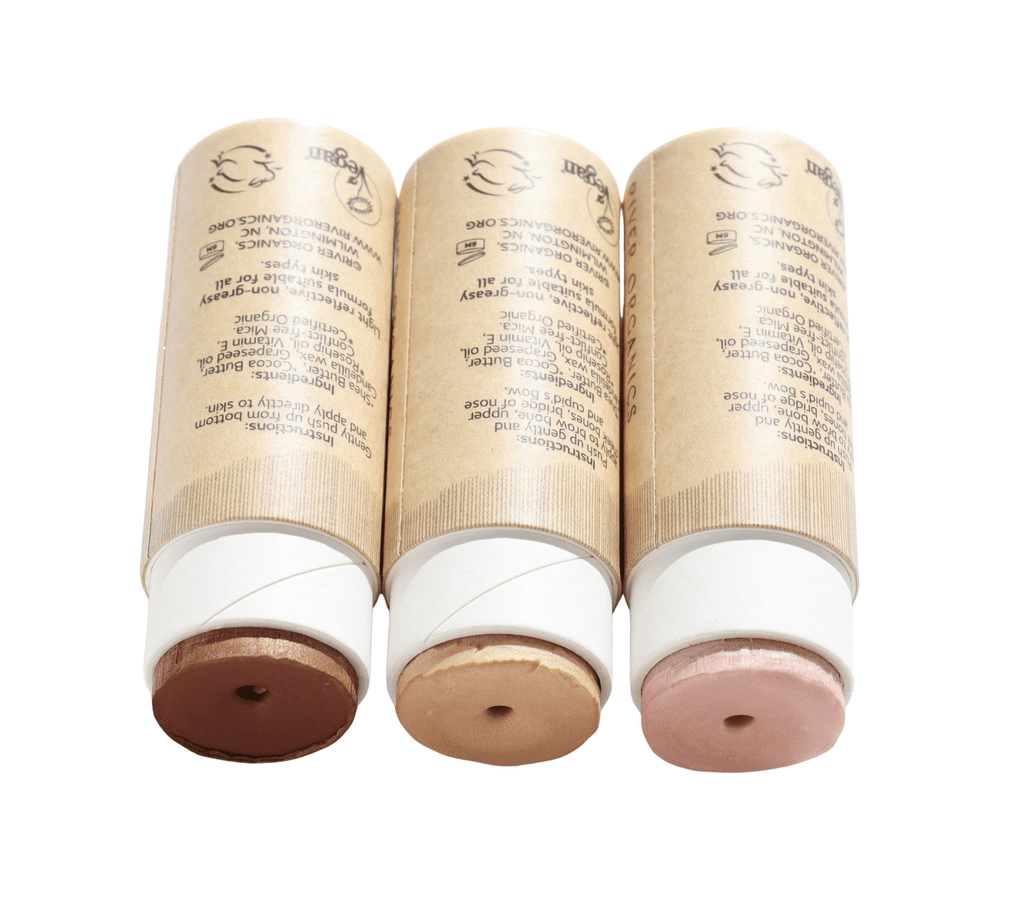Three cosmetic sticks with paper packaging on a white background