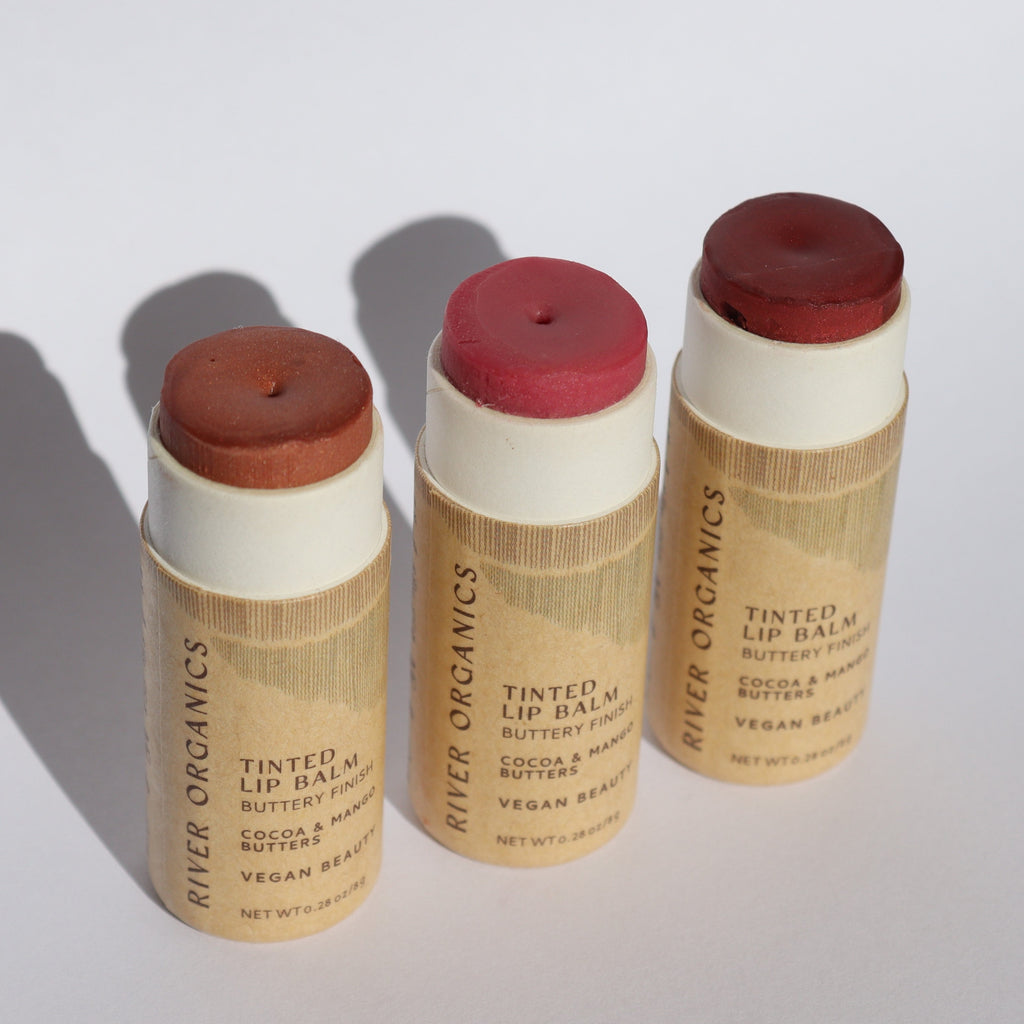 Three River Organics tinted lip balms in paper tubes on a white background