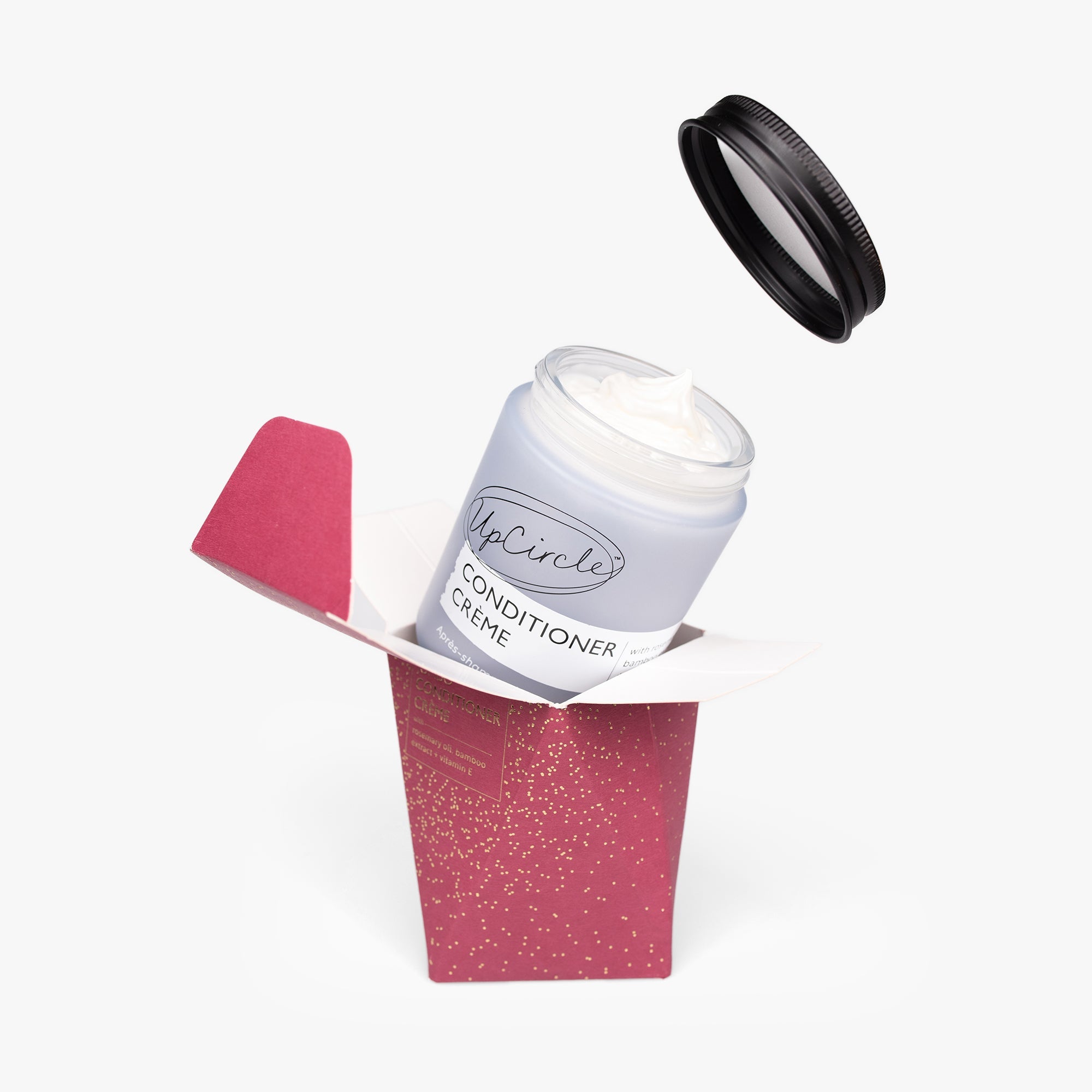 Conditioner cream in a red box with a black lid on a white background