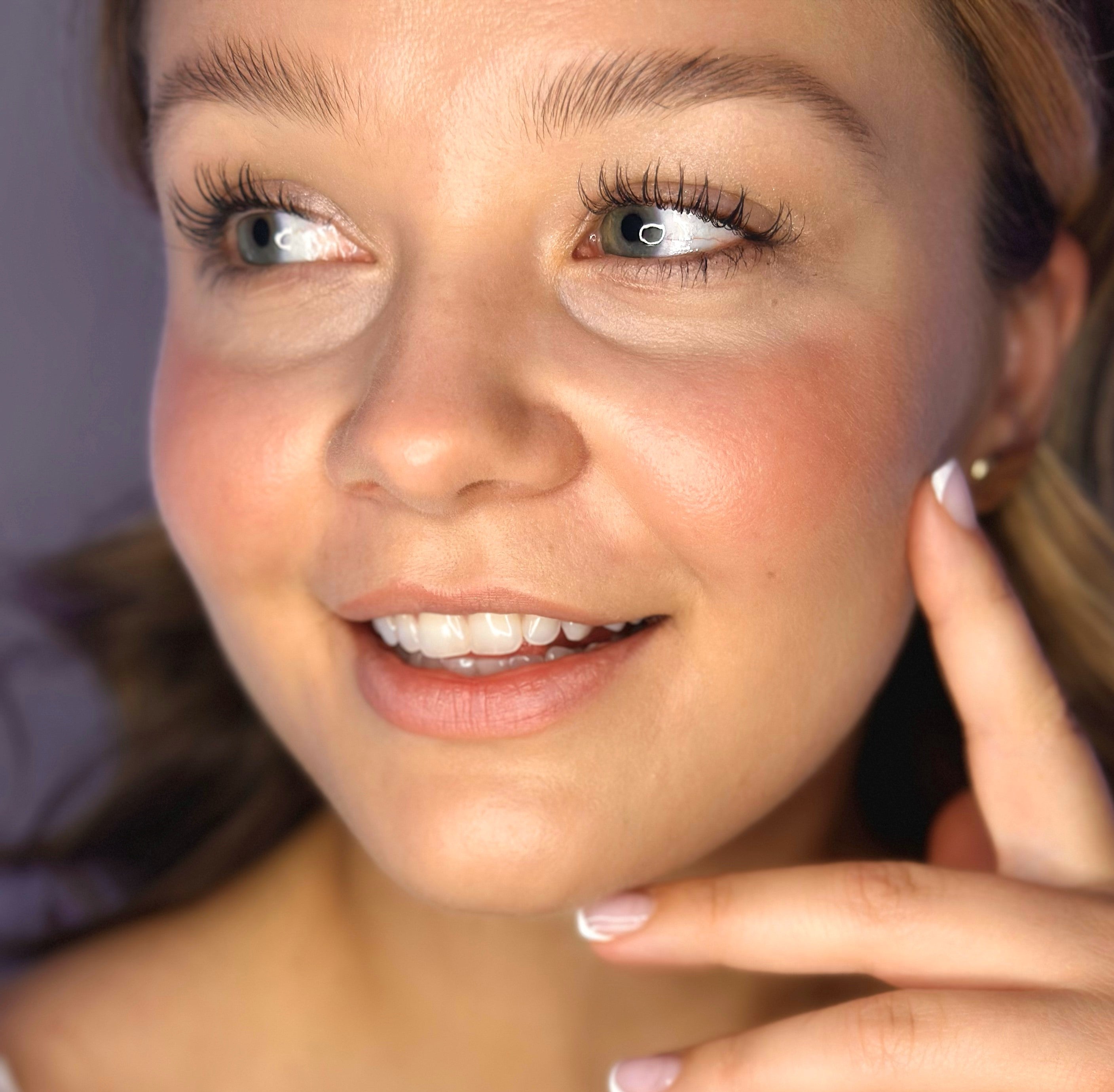 Close-up of a woman's face wearing blush with a blurred background