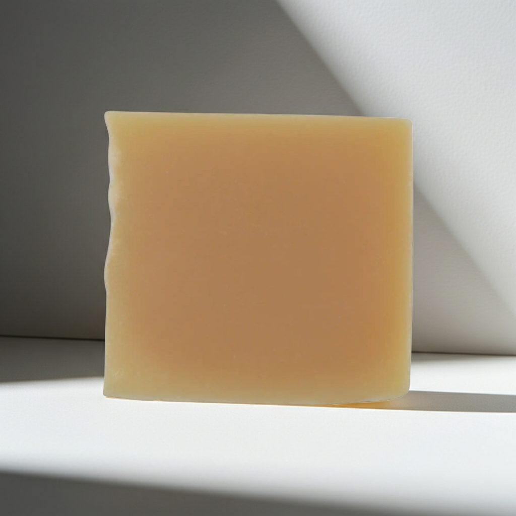 Bar of soap on a white surface with a gray background