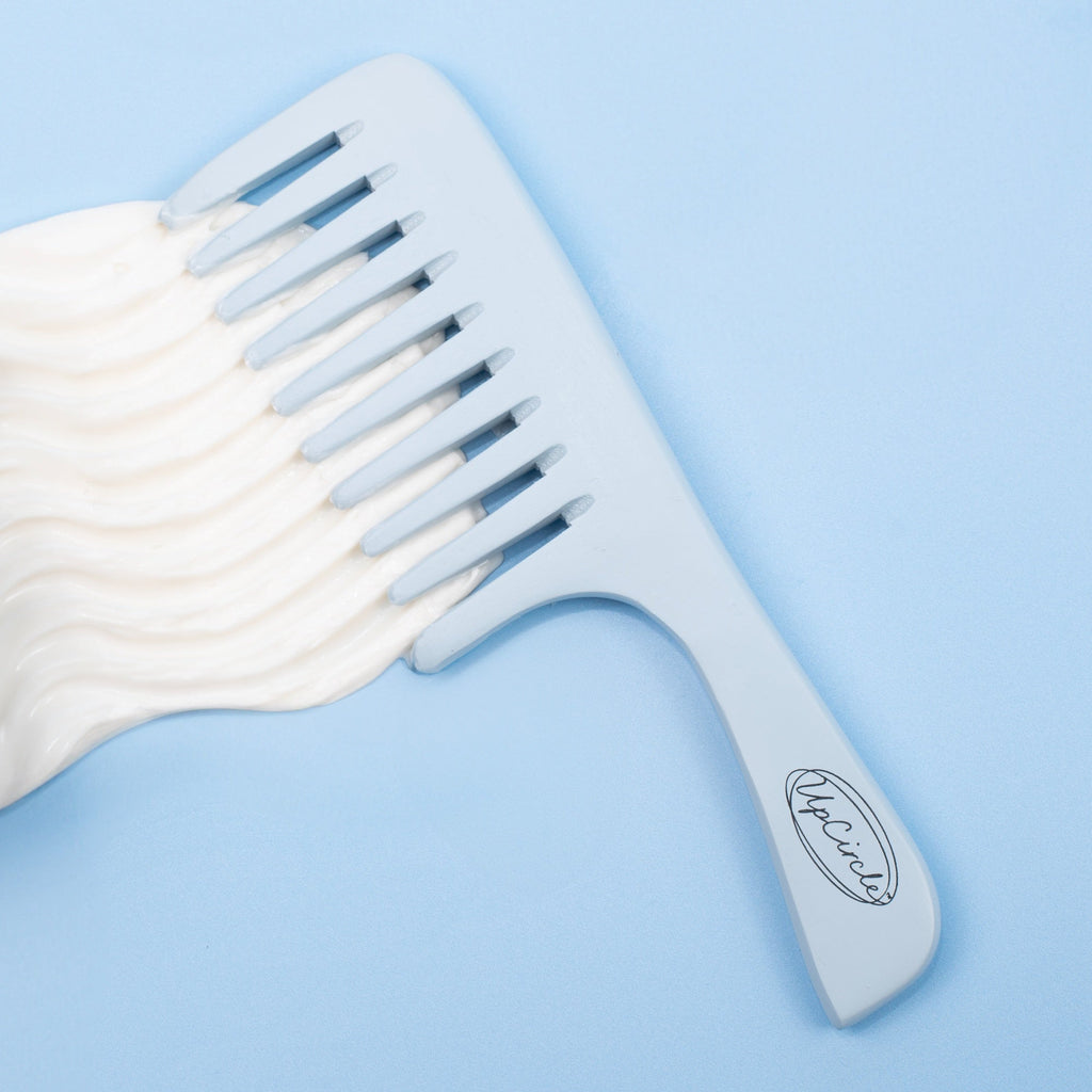 White wide-tooth comb on a light blue background