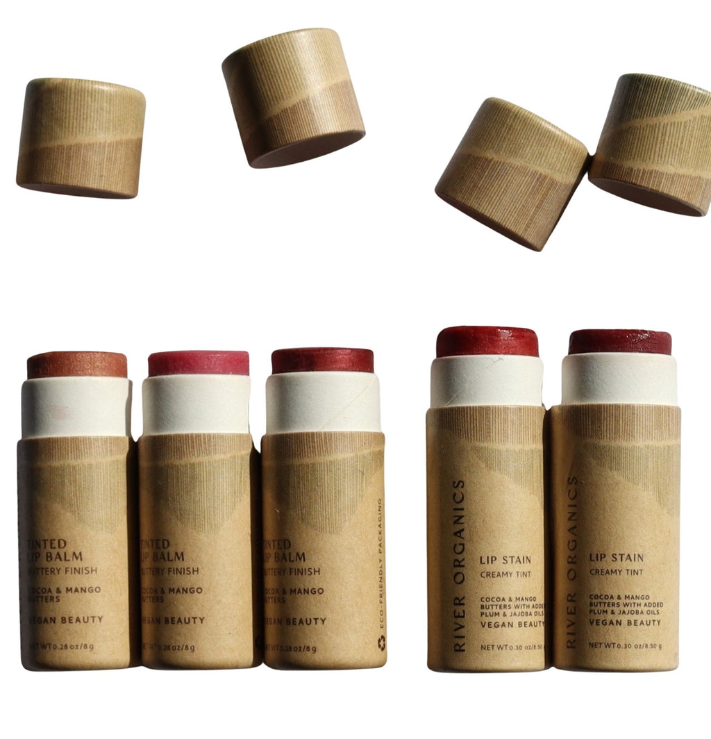 Set of lip balm and lip stain products with paper caps on a white background