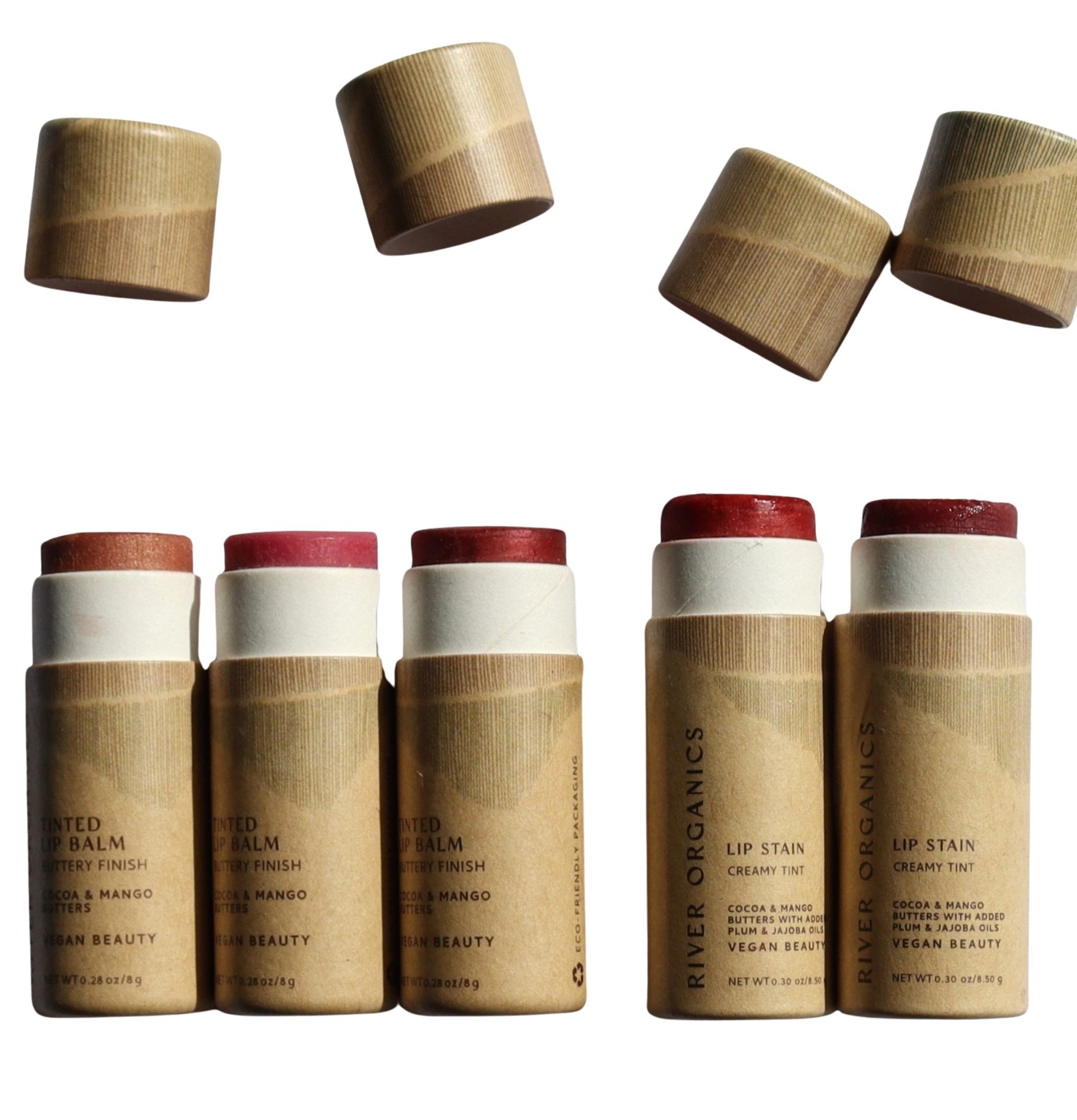 Set of lip balm and lip stain products with paper caps on a white background