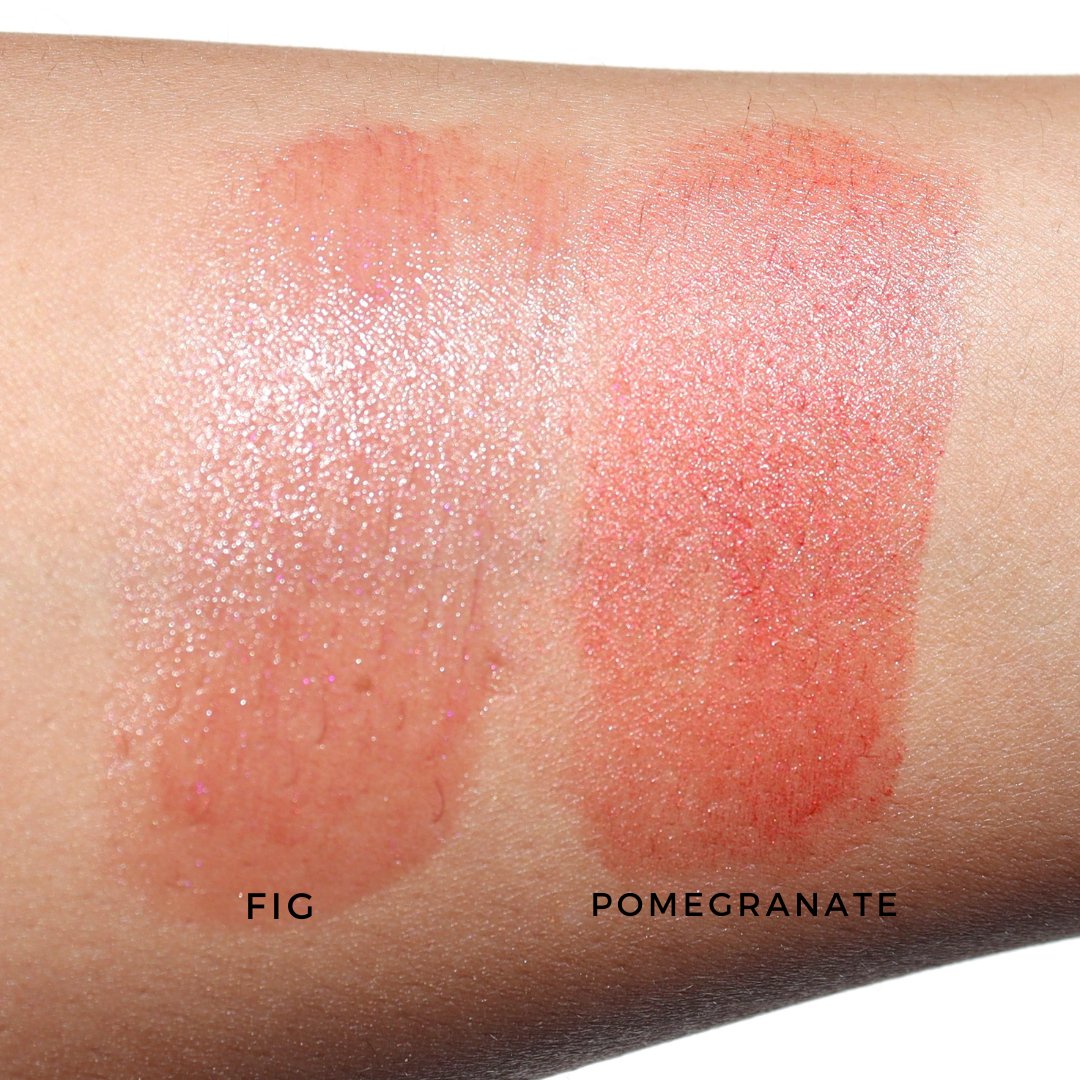 Lipstick swatches labeled 'Fig' and 'Pomegranate' on a person's arm.