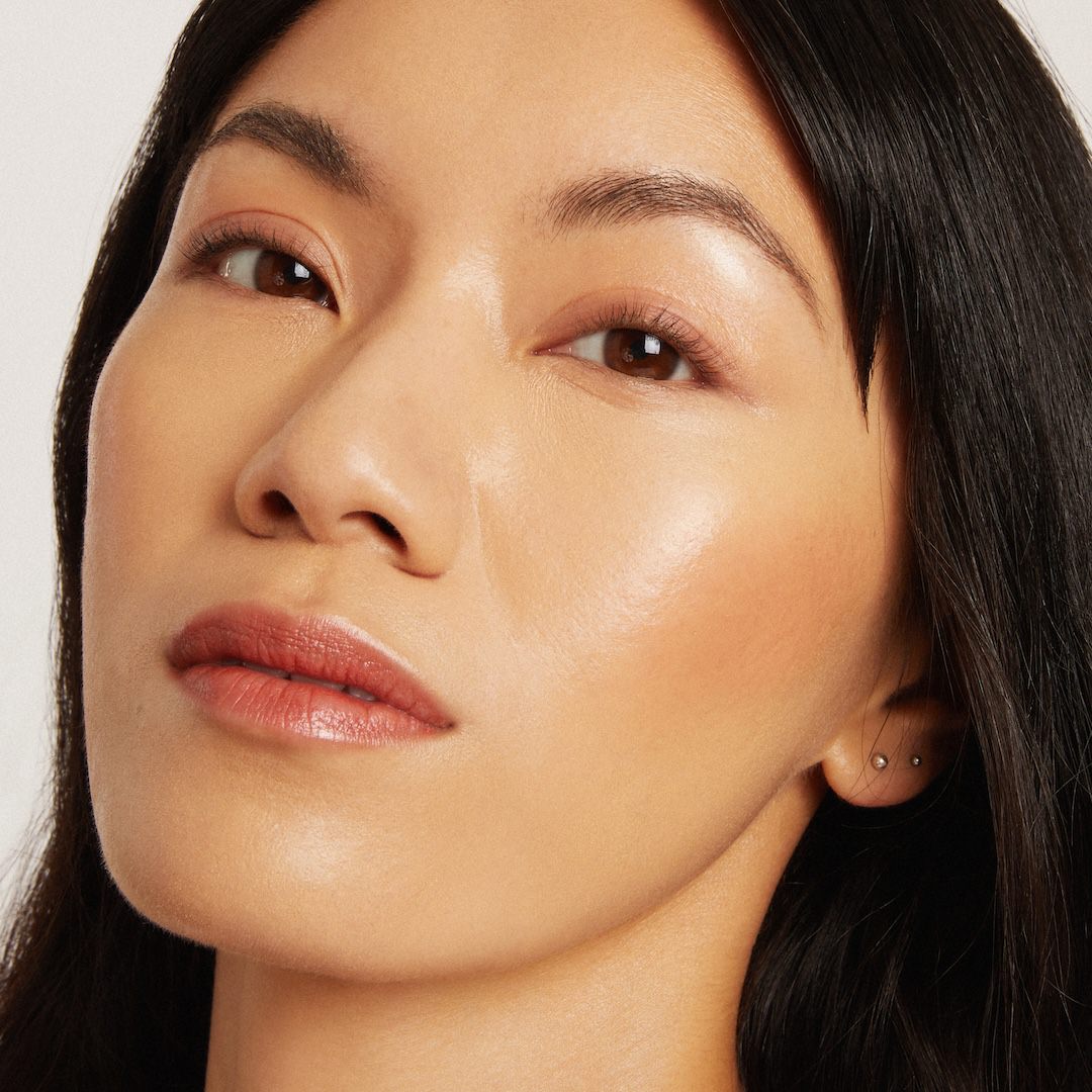 Close-up of a woman's face wearing makeup with a neutral background