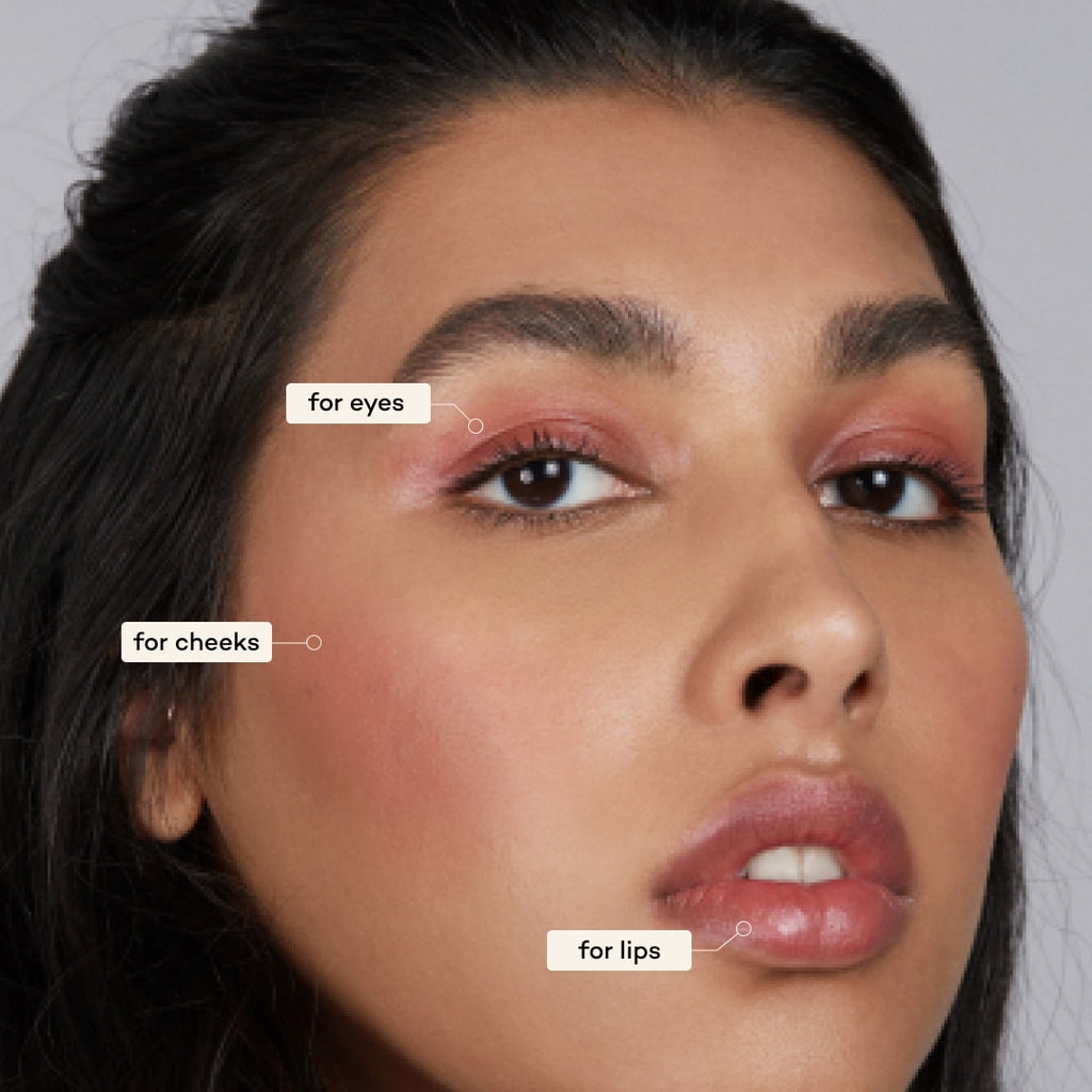 Close-up of a woman's face with makeup application labels on her cheeks and lips.