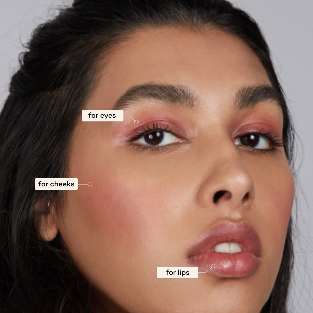 Close-up of a woman's face with makeup application labels on her cheeks and lips.