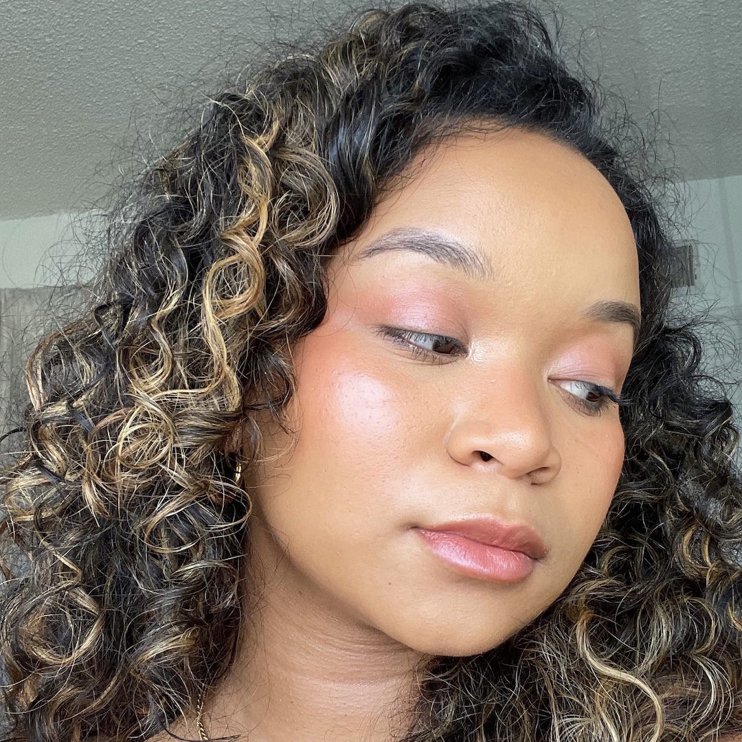 Close-up of a person with curly hair and makeup