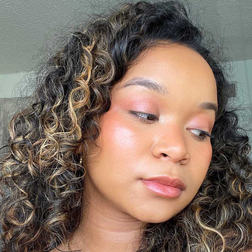 Close-up of a person with curly hair and makeup