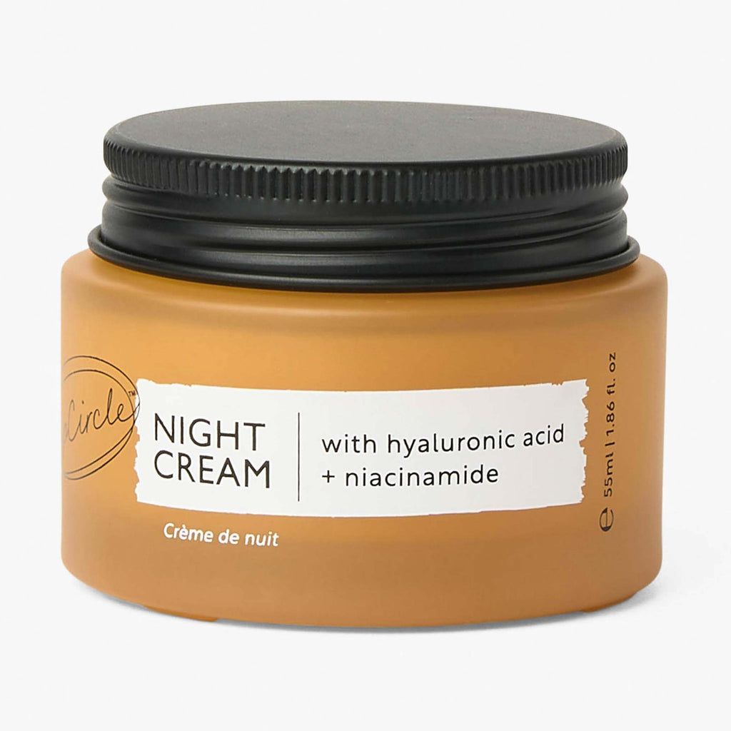 Jar of night cream with black lid on a white background