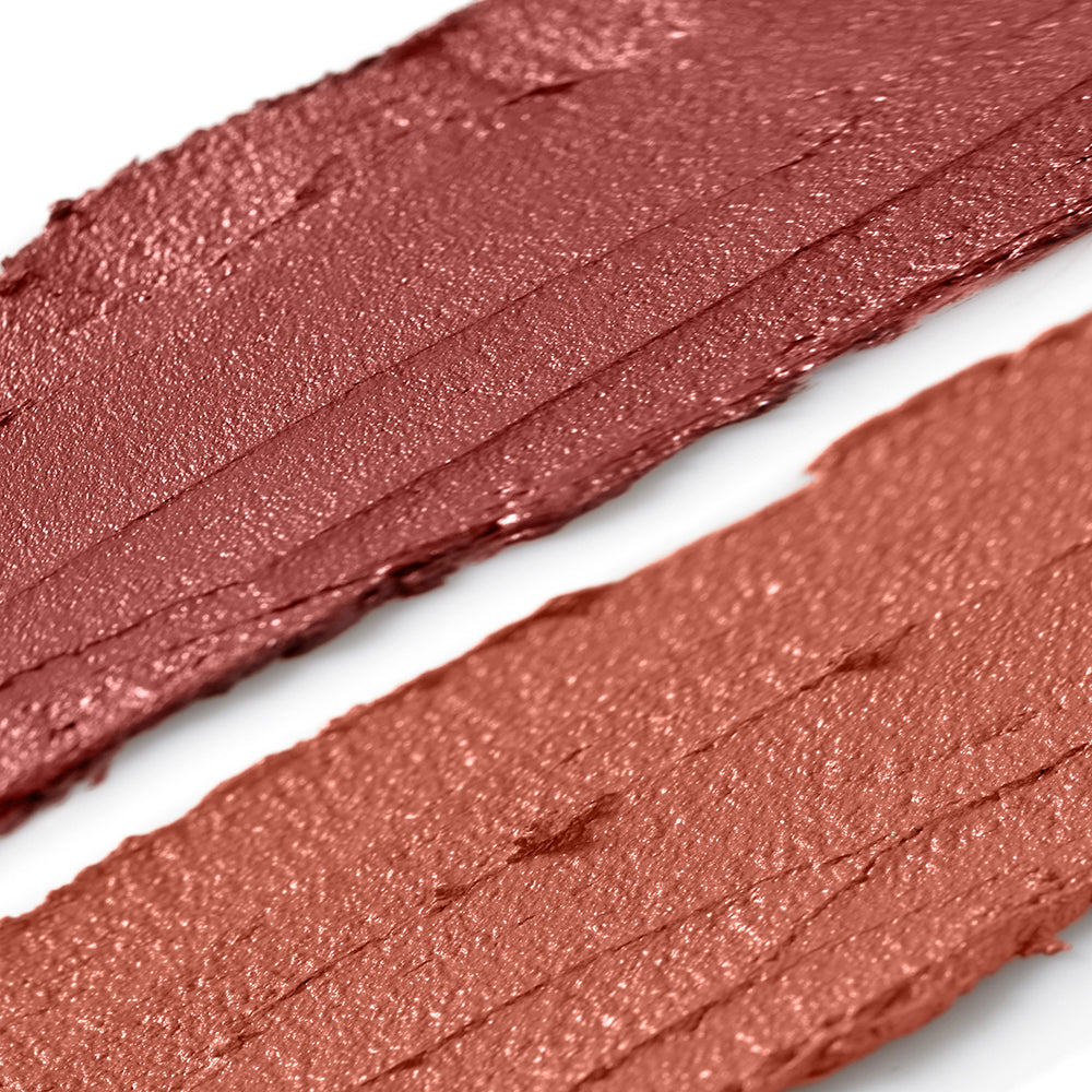 Close-up of two swatches of a bronze-colored makeup product on a white background
