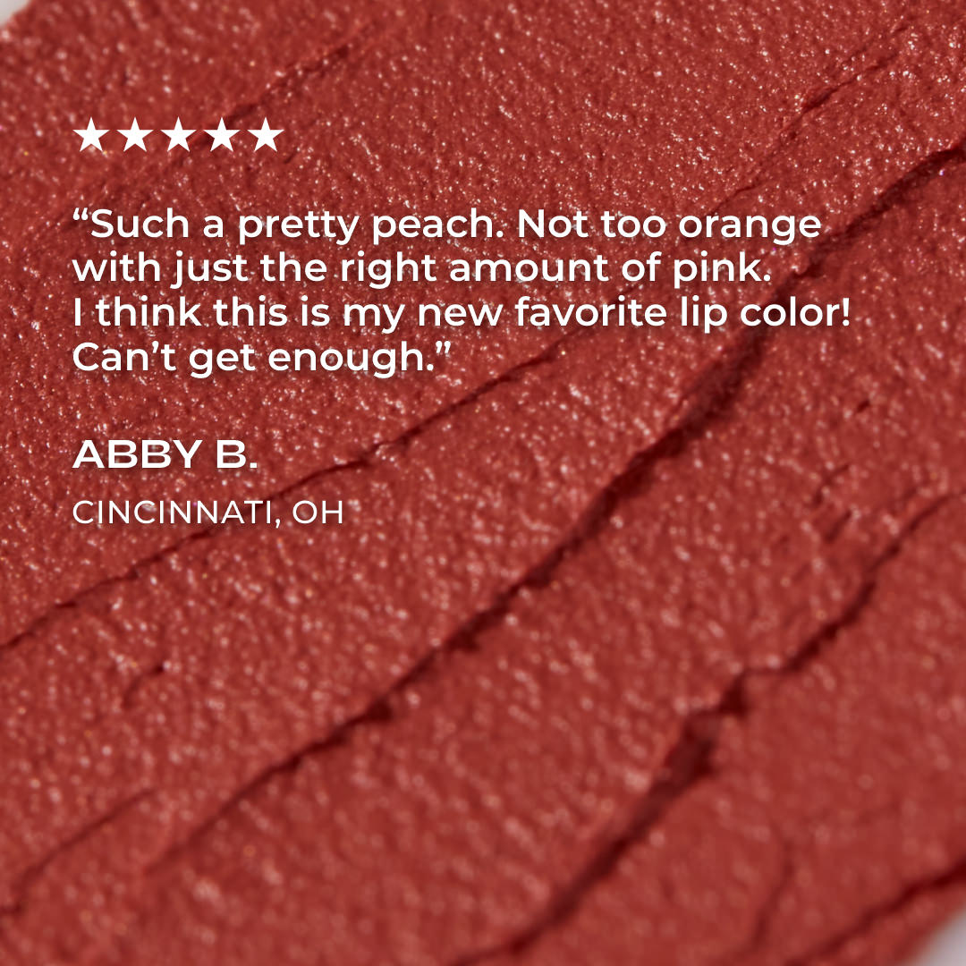 Close-up of a peach-colored lip color with a five-star rating and review text on a red background.