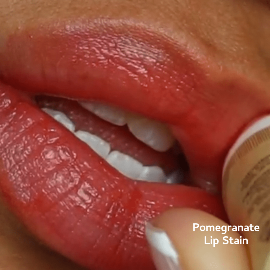 Close-up of lips with pomegranate lip stain and a product tube.