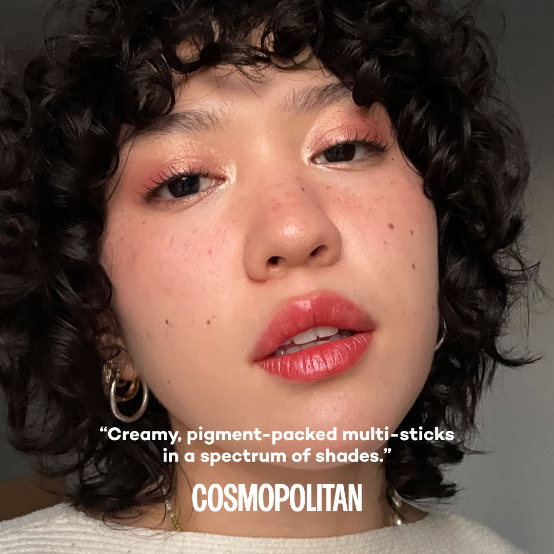 Close-up of a person with text by Cosmopolitan about products on a gray background