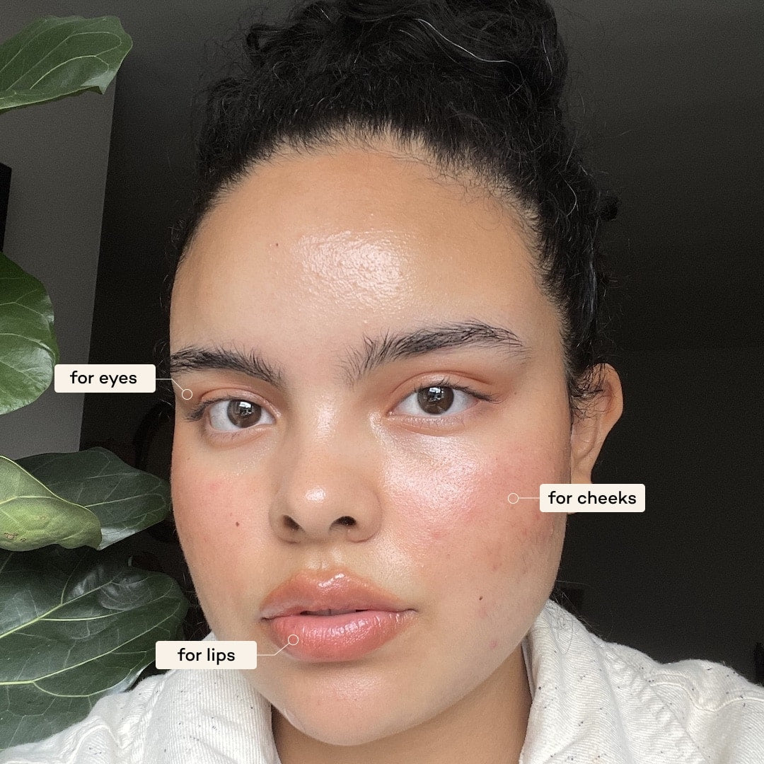 Woman applying makeup to her face with labels for eyes, cheeks, and lips.