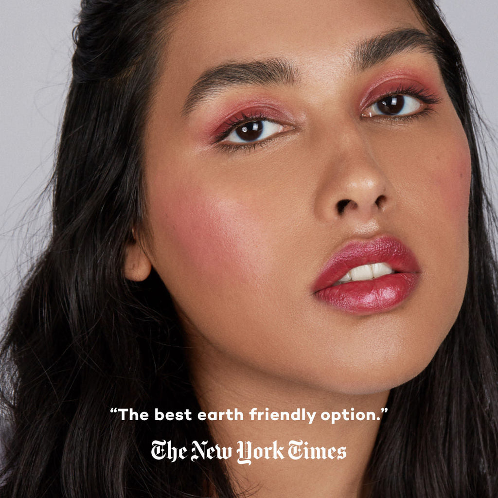 Close-up of a woman's face with makeup, featuring a quote from The New York Times.