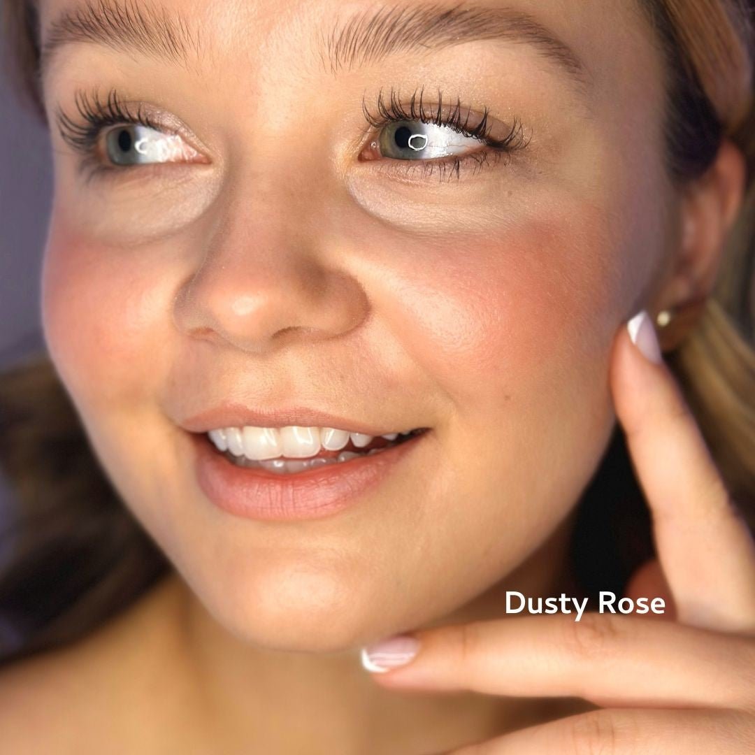 Close-up of a woman's face with a hand near her ear, wearing blush, labeled 'Dusty Rose'.
