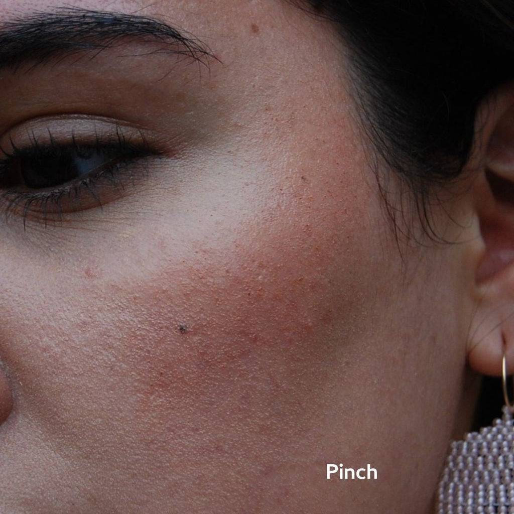 Close-up of a person's face wearing blush and 'Pinch' text.