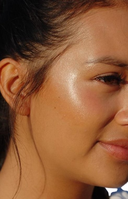 Close-up of a person's face with a focus on the highlighter makeup.