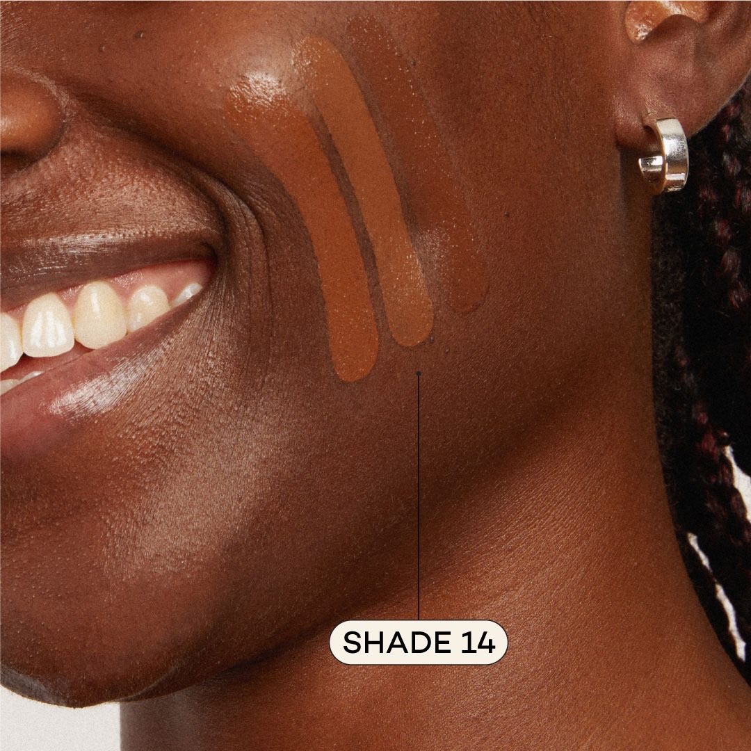 Close-up of a person's neck with brown foundation swatches labeled 'Shade 14' on a neutral background