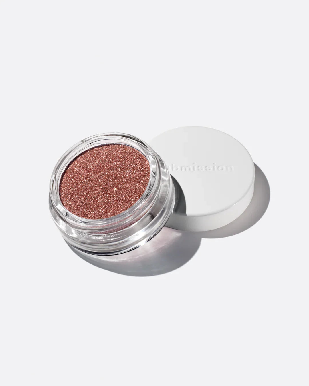 Glittery bronze makeup in an open container on a white background
