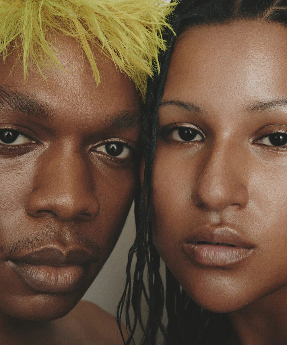 Two people with close-up faces, with a focus on luminus skin, against a neutral background.
