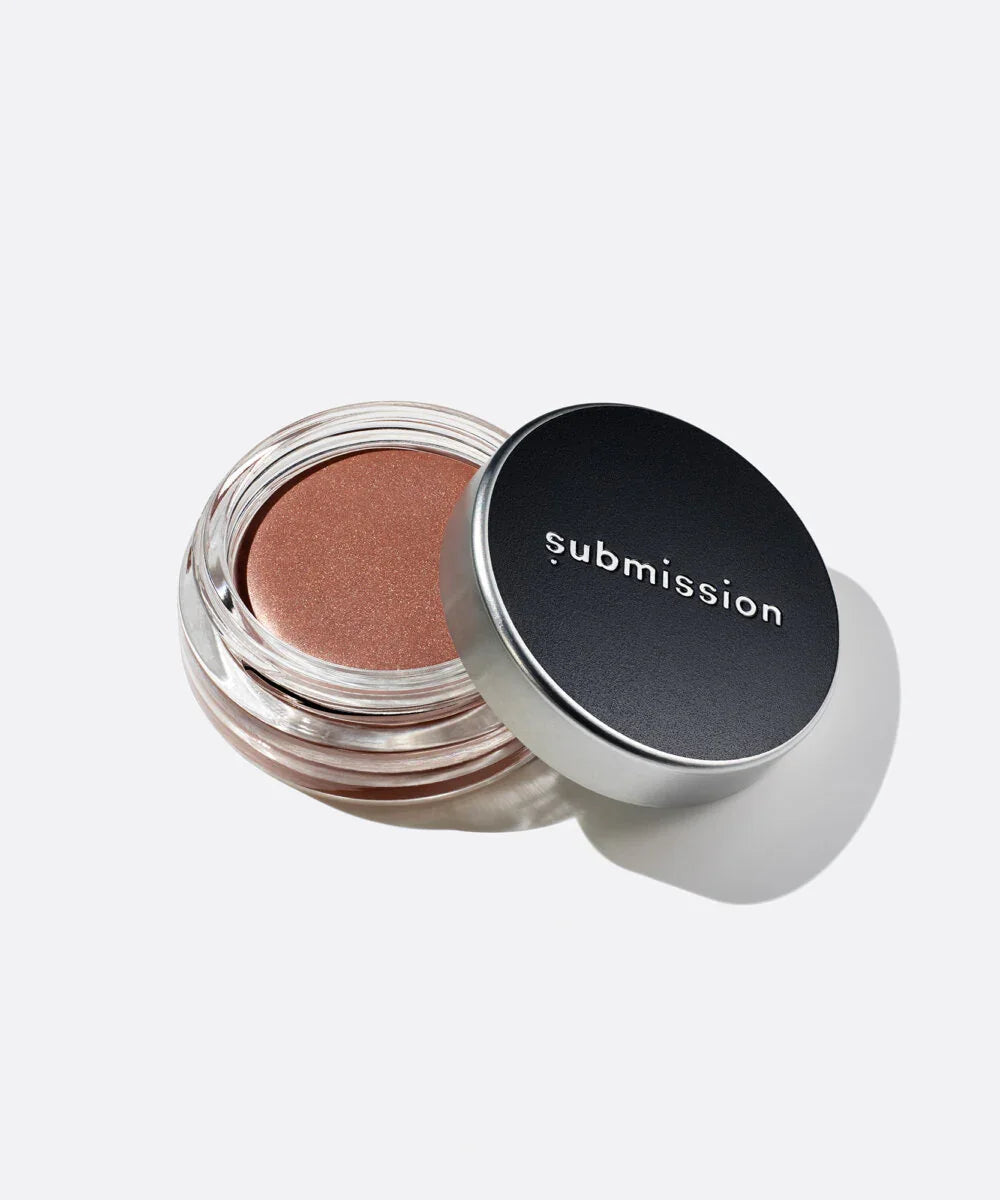 Open jar of brown highlighter with 'submission' brand on a white background