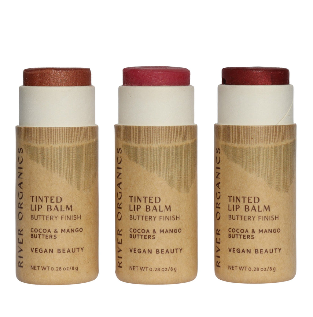 Three River Organics tinted lip balms with brown and white packaging on a white background