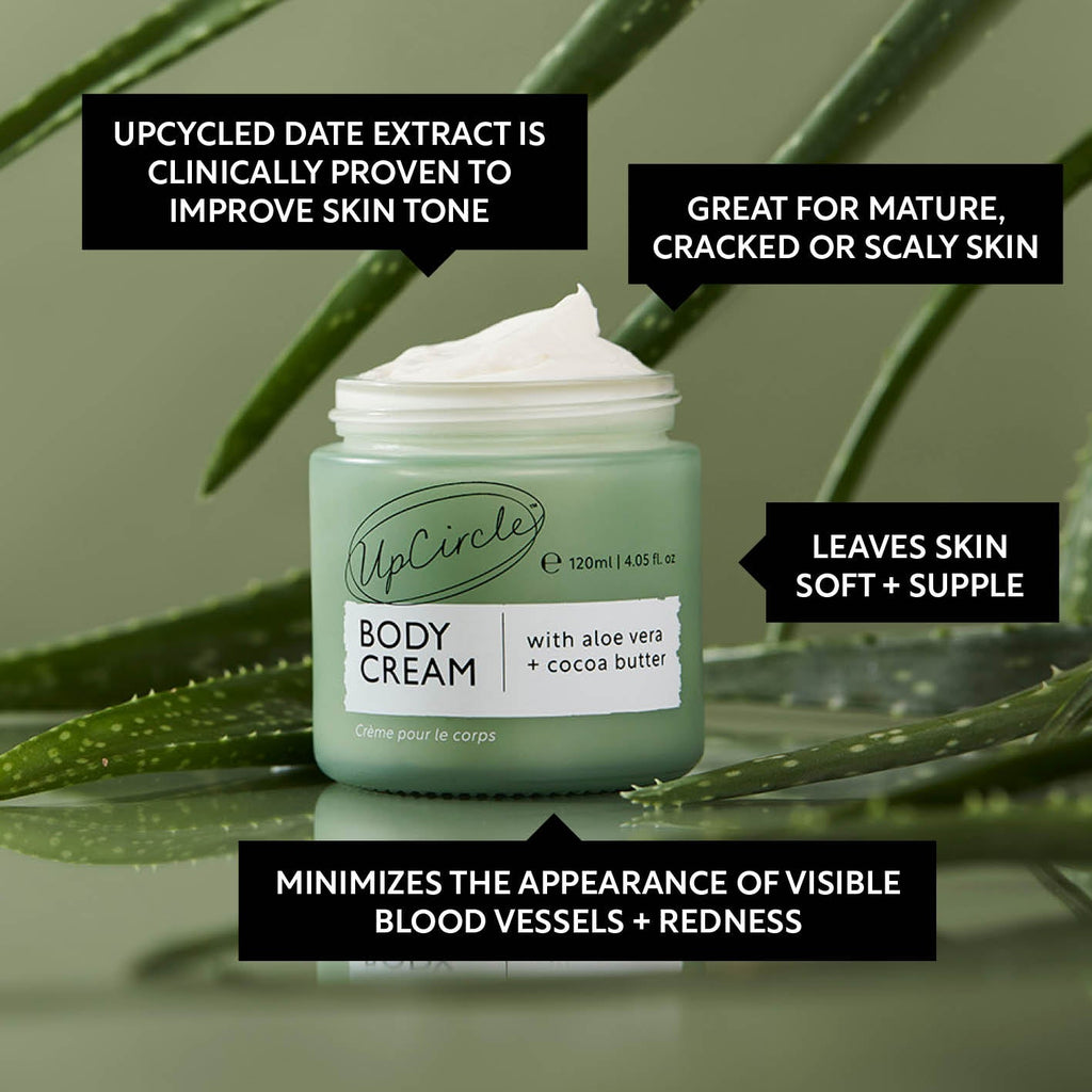 UpCircle body cream jar with aloe vera and cocoa butter on a green leaf background