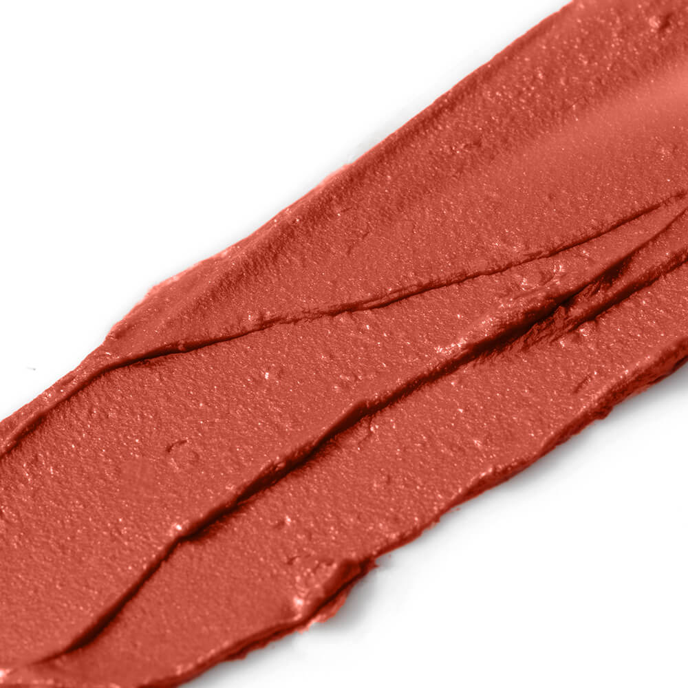 Close-up of a swatch of red-brown makeup on a white background