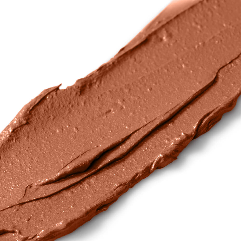 Close-up of a swatch of brown makeup cream on a white background