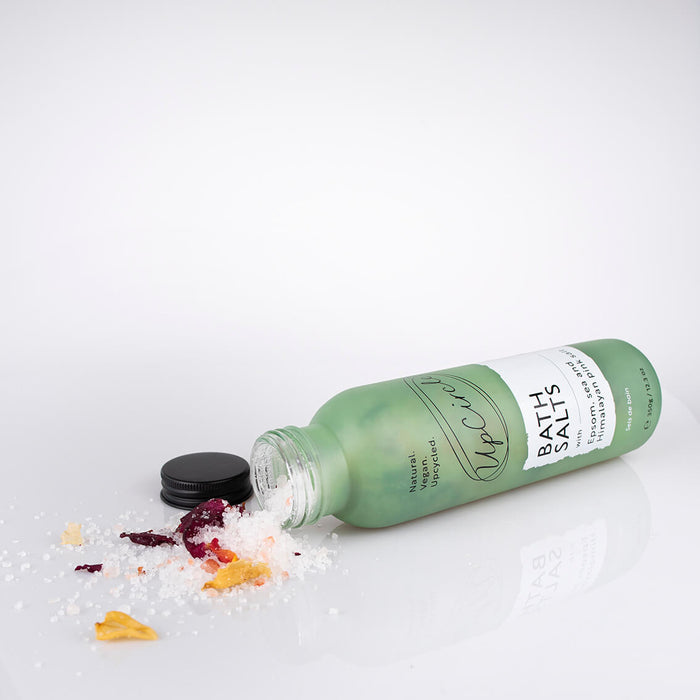 Bottle of bath salts with a white label on a light gray background