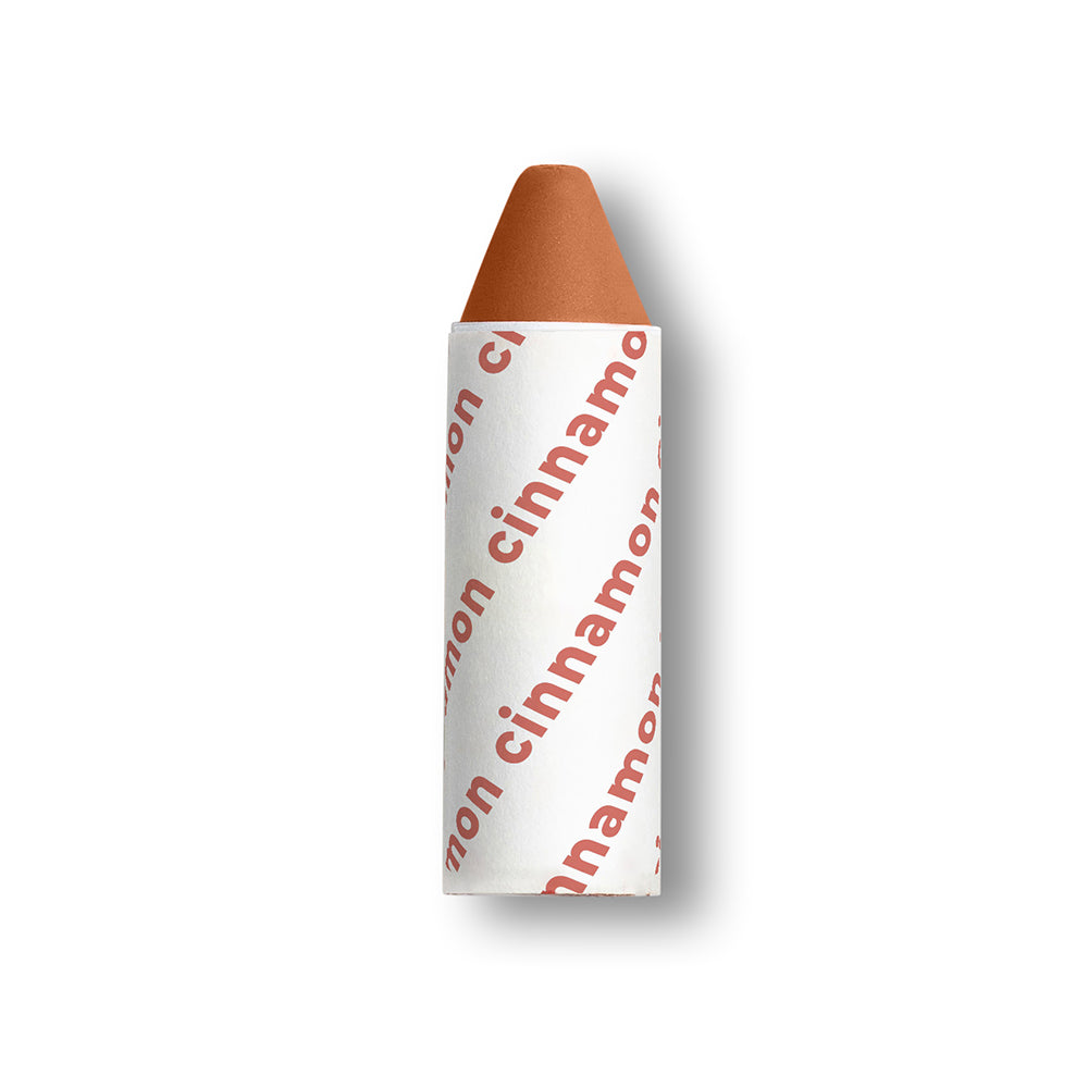 Cinnamon lip crayon with white wrapper and red text on a white background