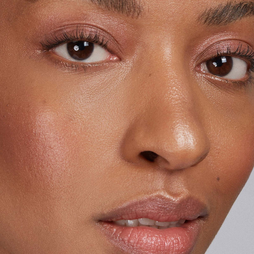 Close-up of a person's face with makeup and a neutral background