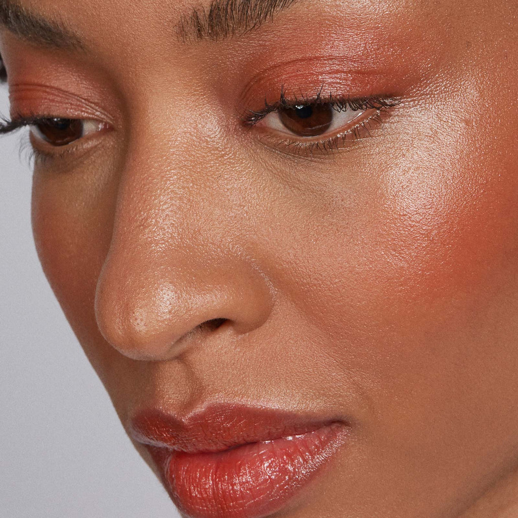 Close-up of a woman's face with makeup on a neutral background