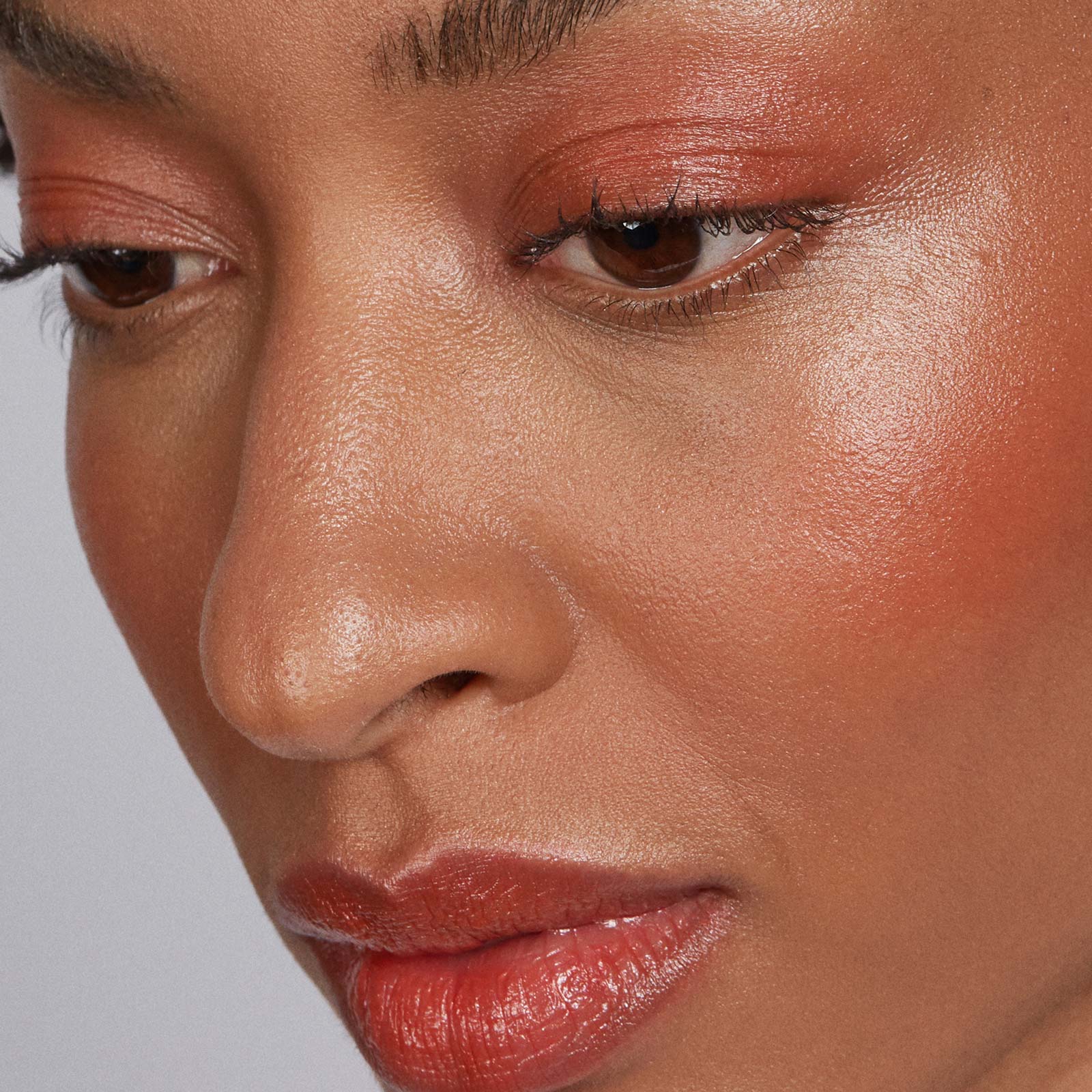 Close-up of a woman's face with makeup on a neutral background