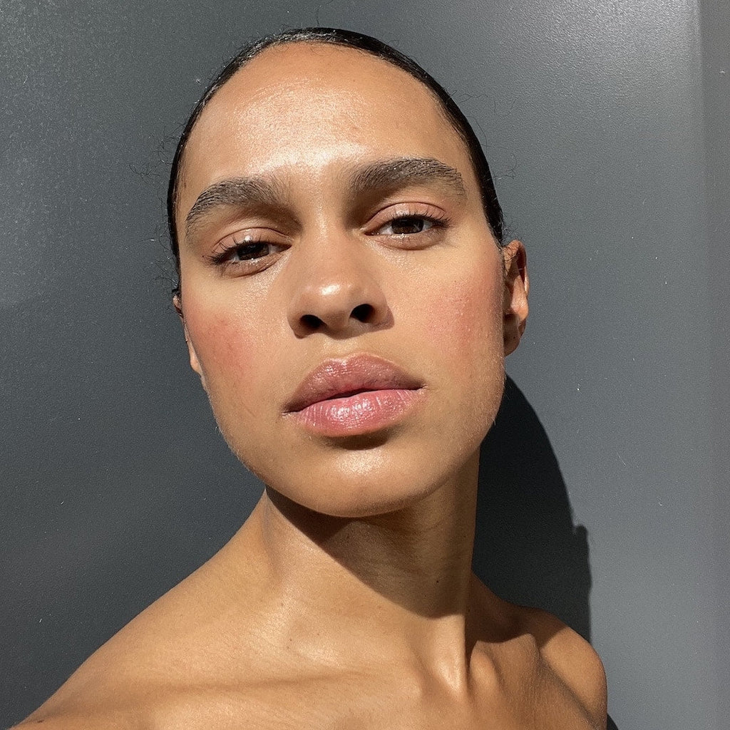 Close-up of a person with a neutral expression against a gray background