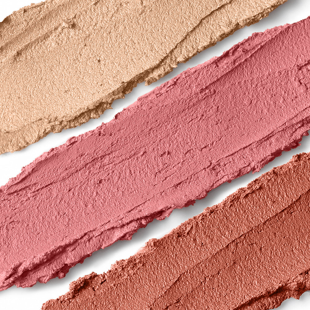 Three swatches of beige, rose, and coral makeup on a white background