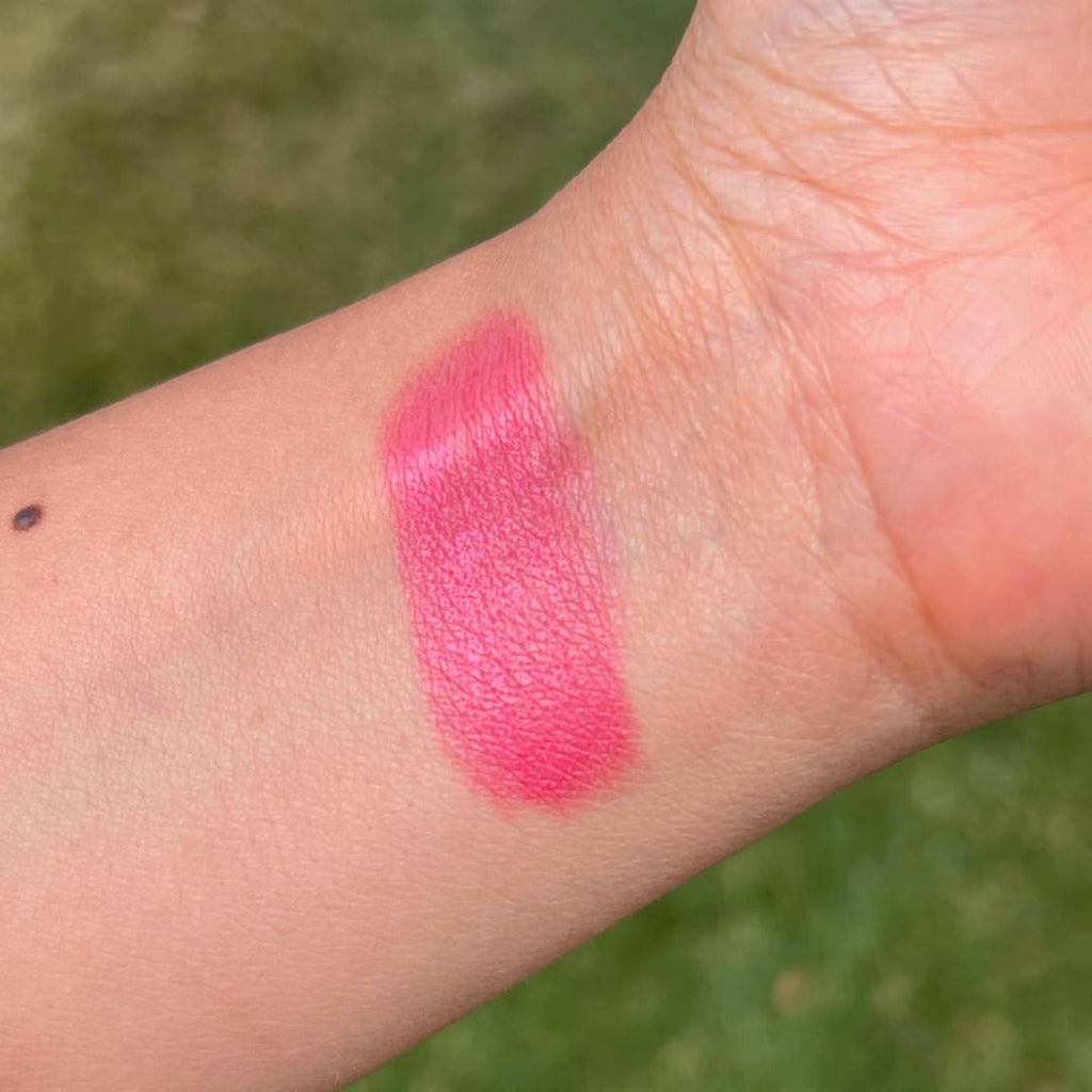 Swatch of pink makeup shown on a person's inner forearm