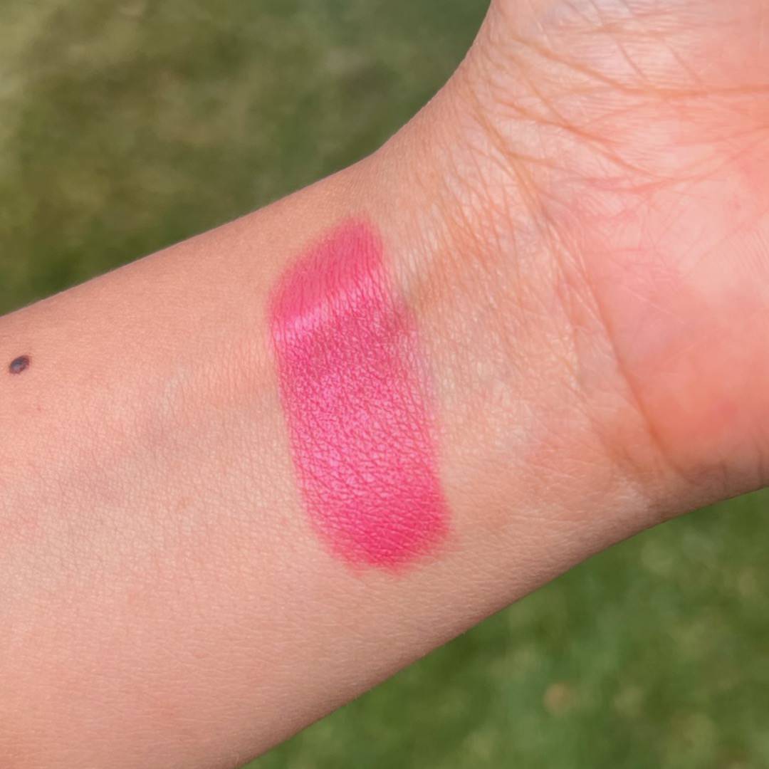 Swatch of pink makeup shown on a person's inner forearm