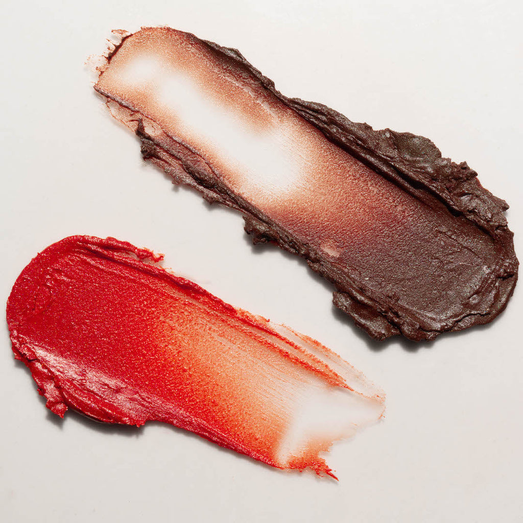 Two swatches of makeup, one brown and one red, on a light gray background.