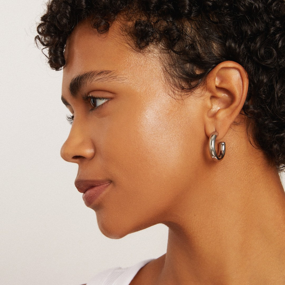 Close-up of a person wearing foundation makeup on a neutral background