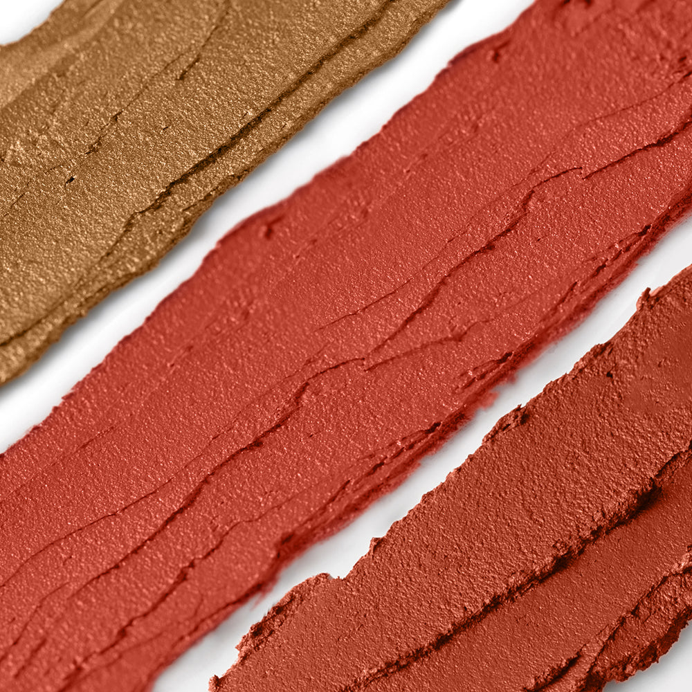 Close-up of brown and red makeup swatches on a white background