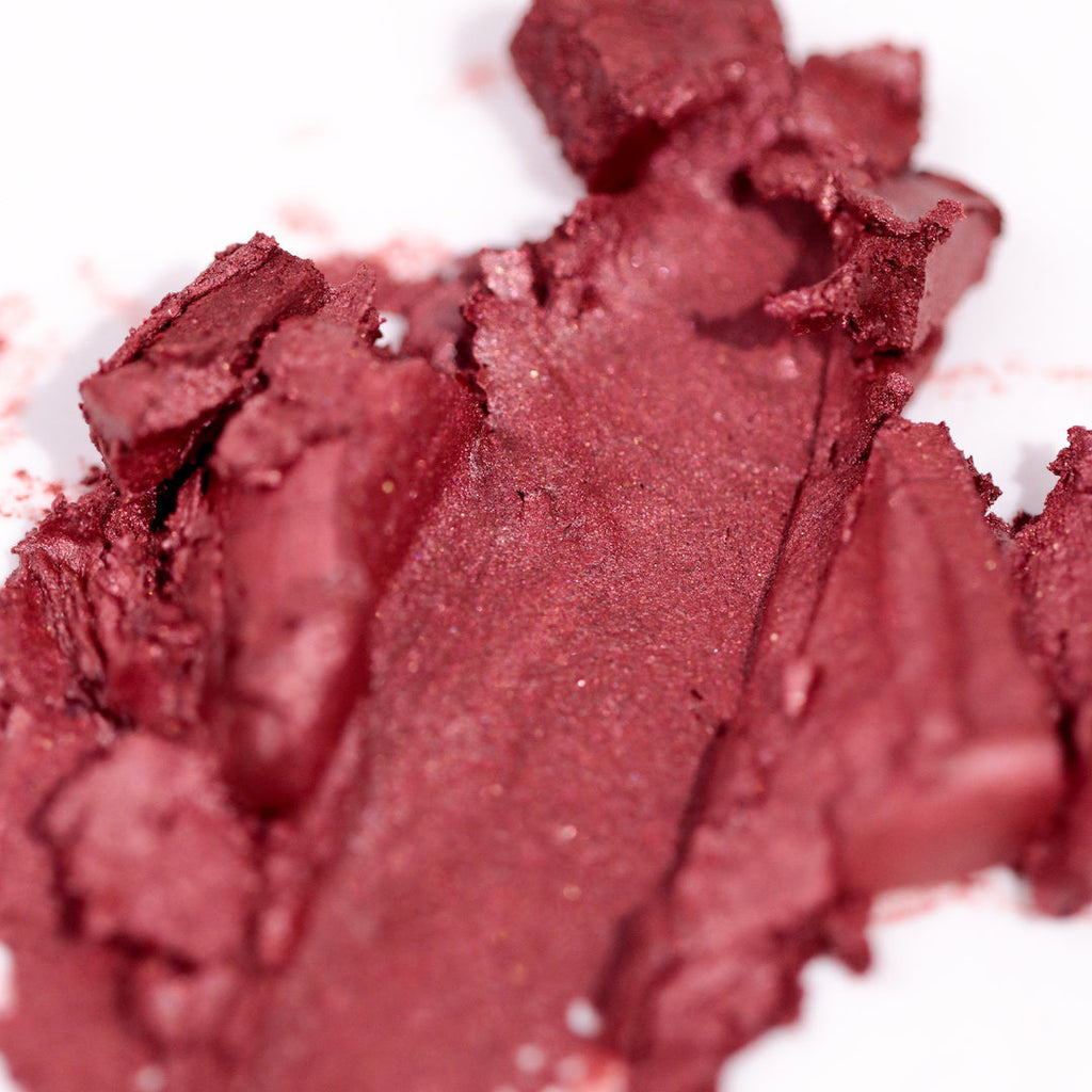 Close-up of a red makeup powder with a white background