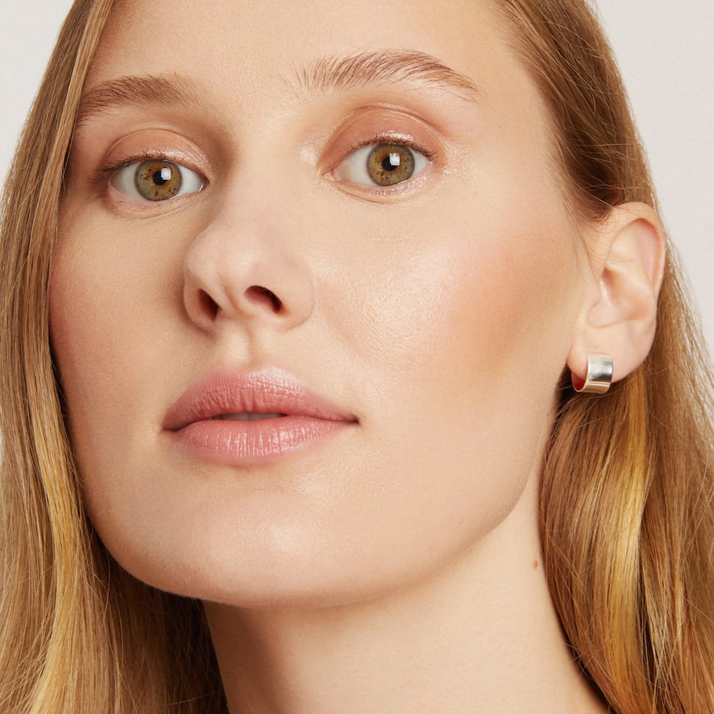 Close-up of a woman's face wearing makeup with a neutral background