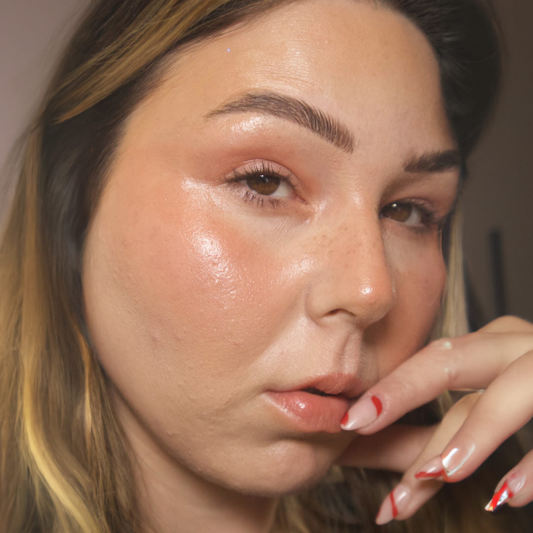 Close-up of a woman's face wearing makeup with a neutral background