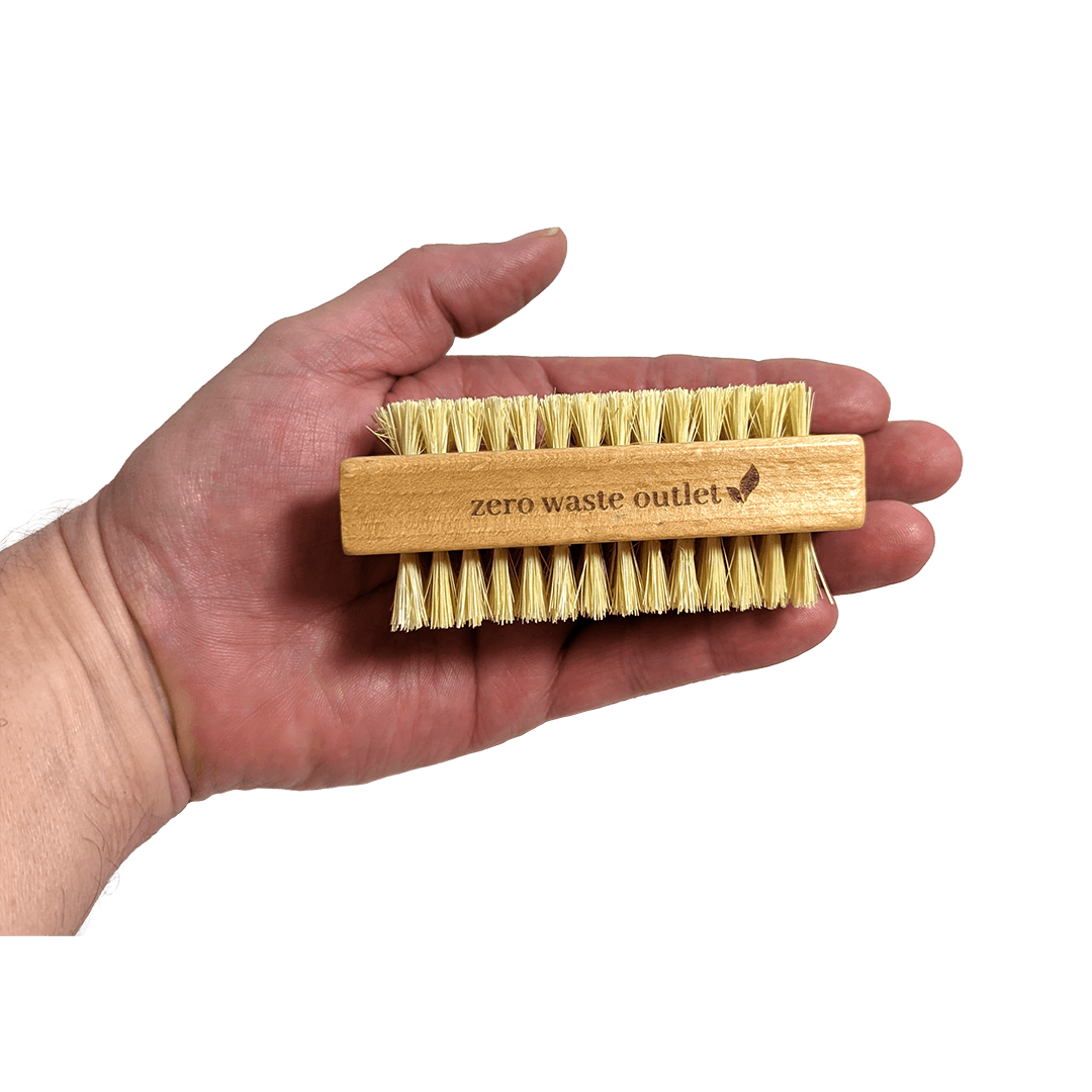 Hand holding a bamboo brush with natural bristles labeled 'zero waste outlet' against a transparent background