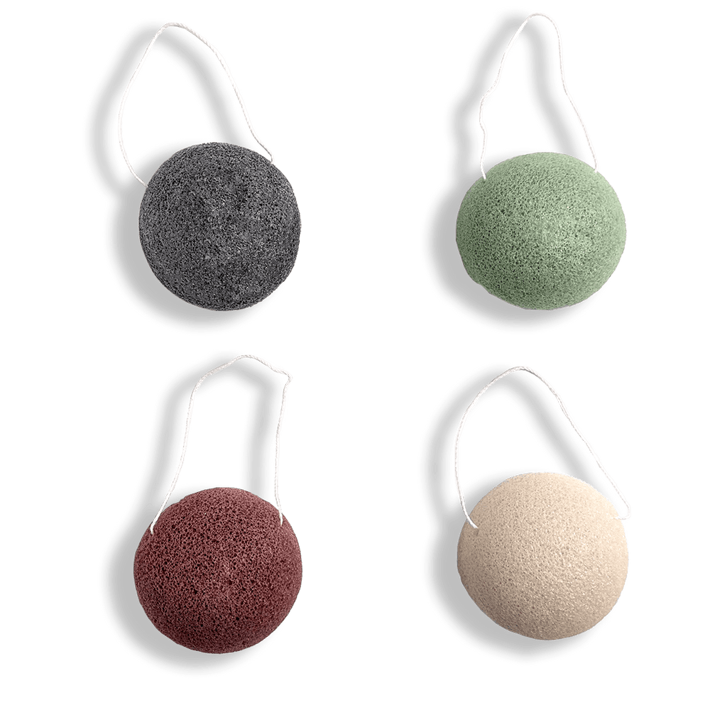 Four konjac sponges with white handles on a transparent background